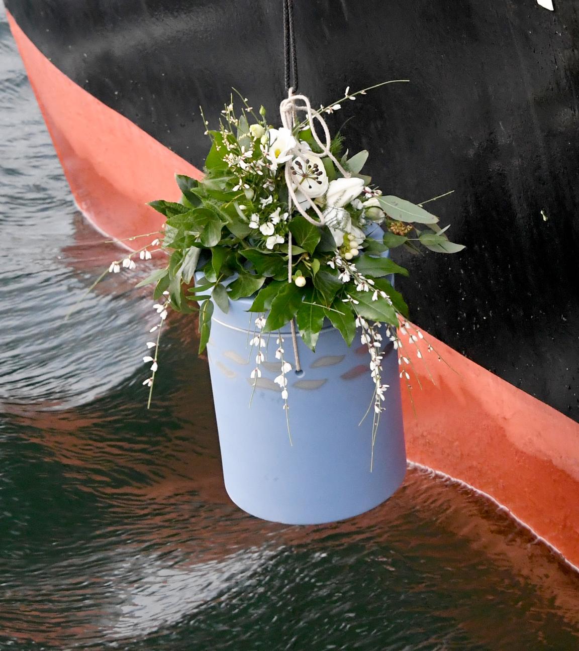 Eine Urne wird zur Seebestattung ins Wasser gelassen. 