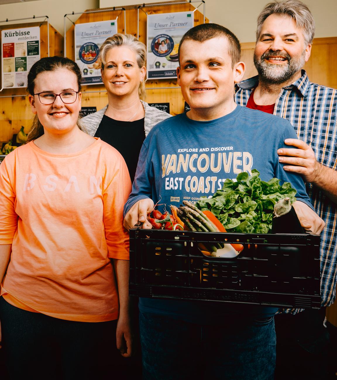Claus und Sandra stehen hinter ihren Kindern, Marina und Lukas in ihrem Naturladen. 
