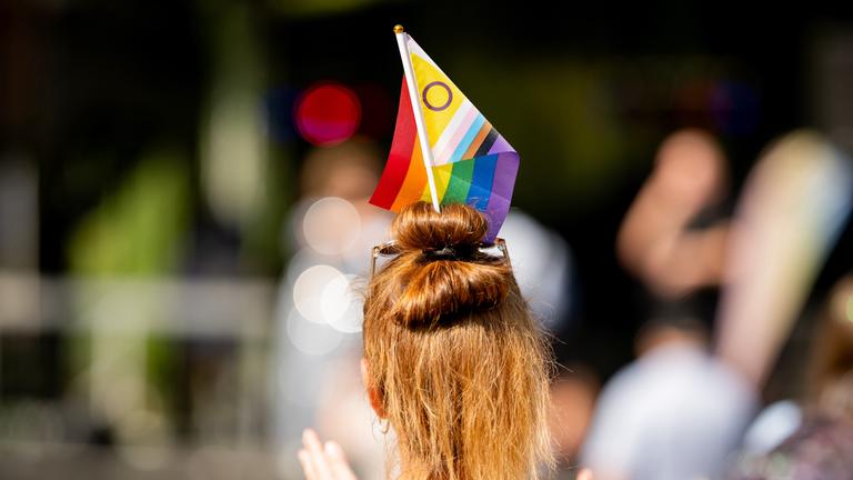 07.09.2024, Thüringen, Erfurt: Eine Teilnehmerin mit einer Inter*Progress-Flag in den Haaren geht beim Christopher Street Day (CSD) durch die Innenstadt.