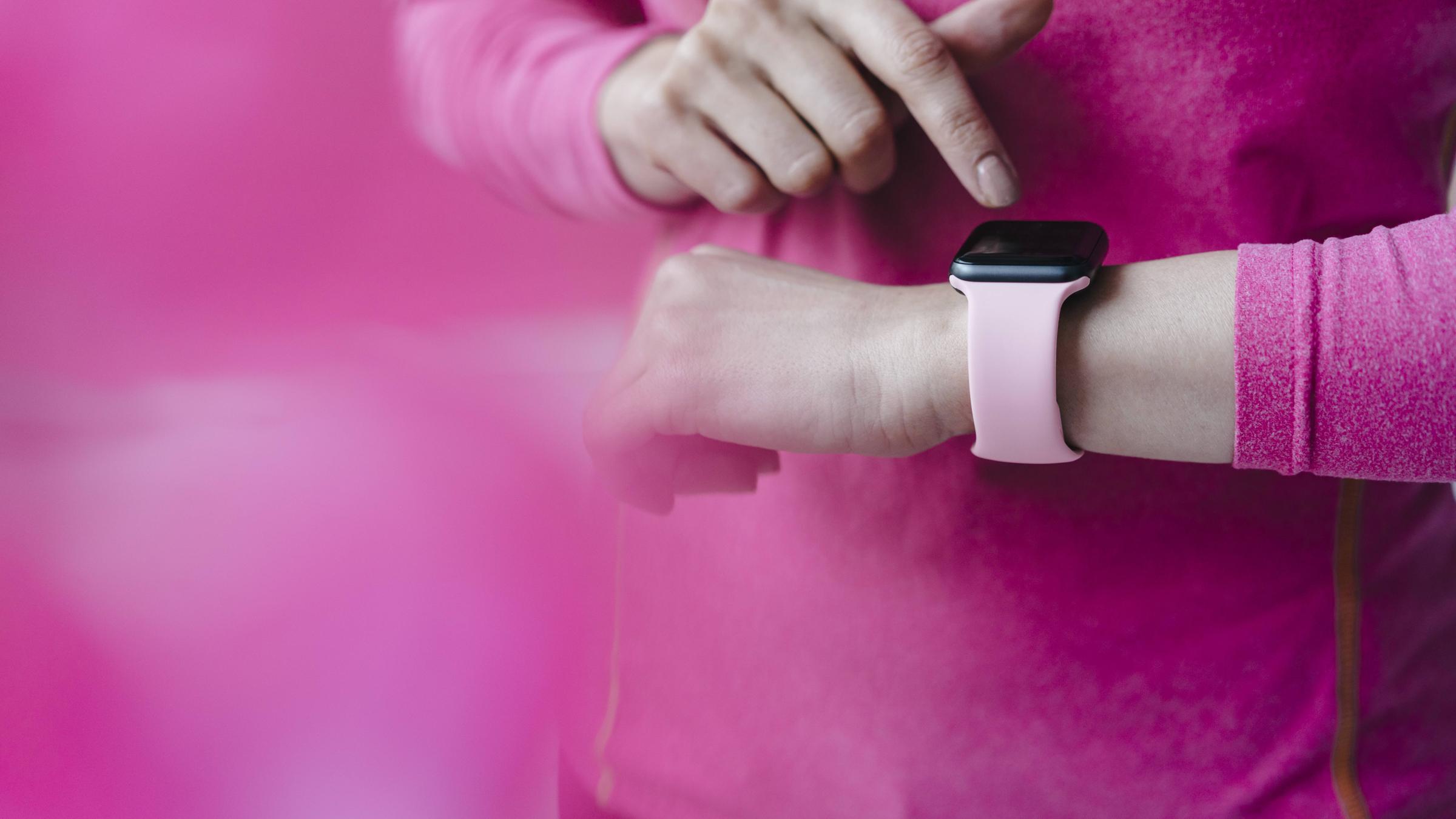 Frau tippt auf Smartwach am Handgelenk.