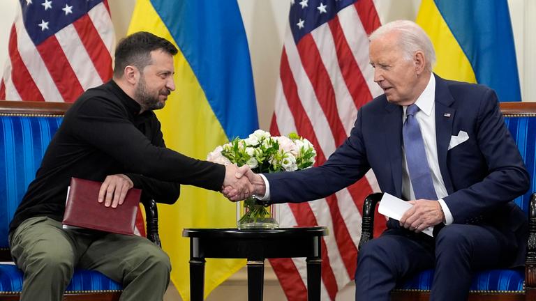 Der ukrainische Präsident Wolodymyr Selenskyj (links) schüttelt in Paris die Hand von US-Präsident Joe Biden (rechts).