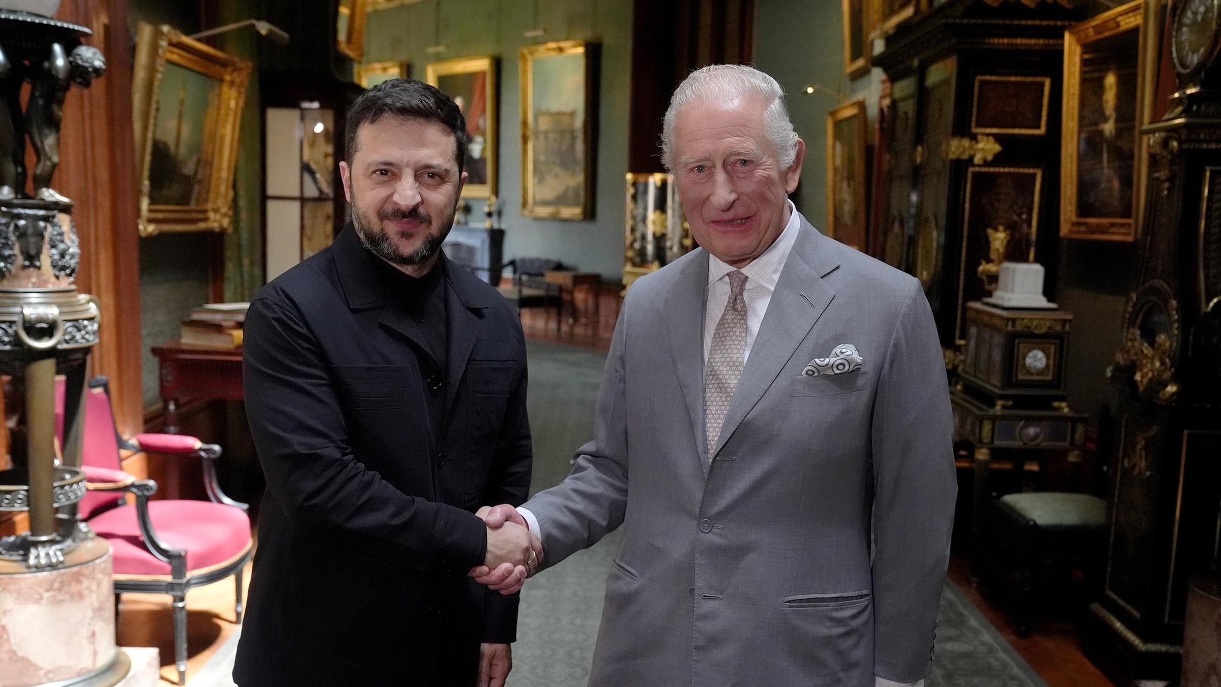 König Charles und Wolodymyr Selenskyj schütteln sich die Hand.
