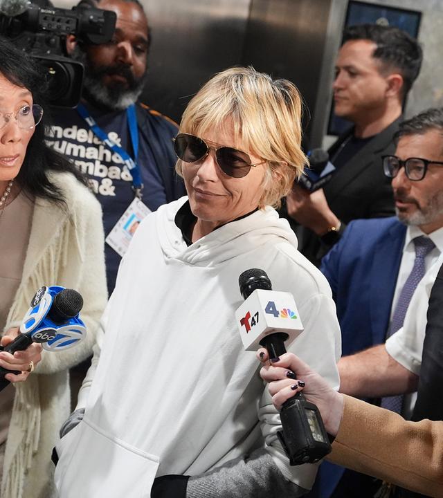 Schauspielerin Selma Blair verlässt umgeben von Jouranlisten ein Gebäude. 