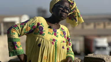 Die senegalesische Aktivistin Yayi Diouf lehnt an einer Mauer.