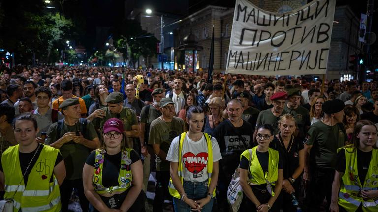 Viele junge Menschen auf einem Protest in der serbischen Hauptstadt Belgrad. Ein großer Banner ist sichtbar