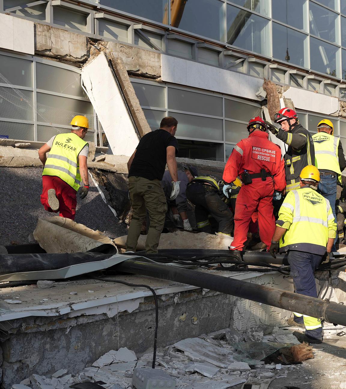 Mitarbeiter von Rettungsdiensten inspizieren das eingestürzte Dach eines Bahnhofs in Novi Sad
