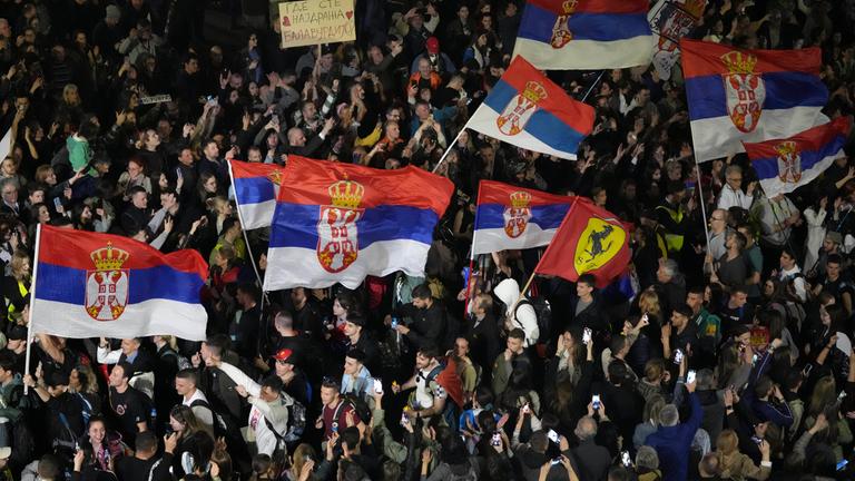 Demonstranten schwenken Fahnen vor einer Großkundgebung am Wochenende in der Innenstadt von Belgrad, Serbien.