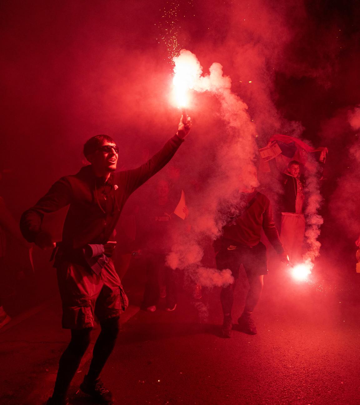 Im Rahmen einer Kundgebung hält eine Person eine brennende Fackel in der Hand.