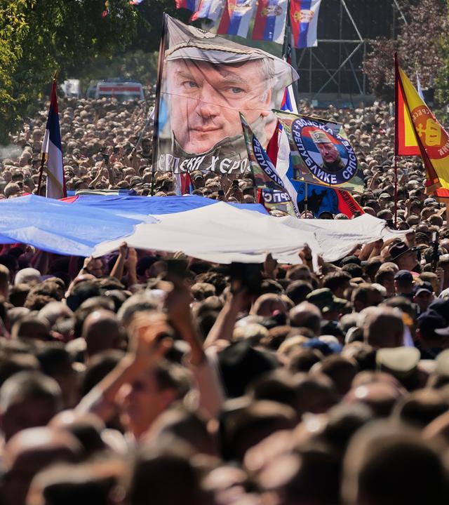 Viele Menschen mit Flaggen und Plakaten von Mladić