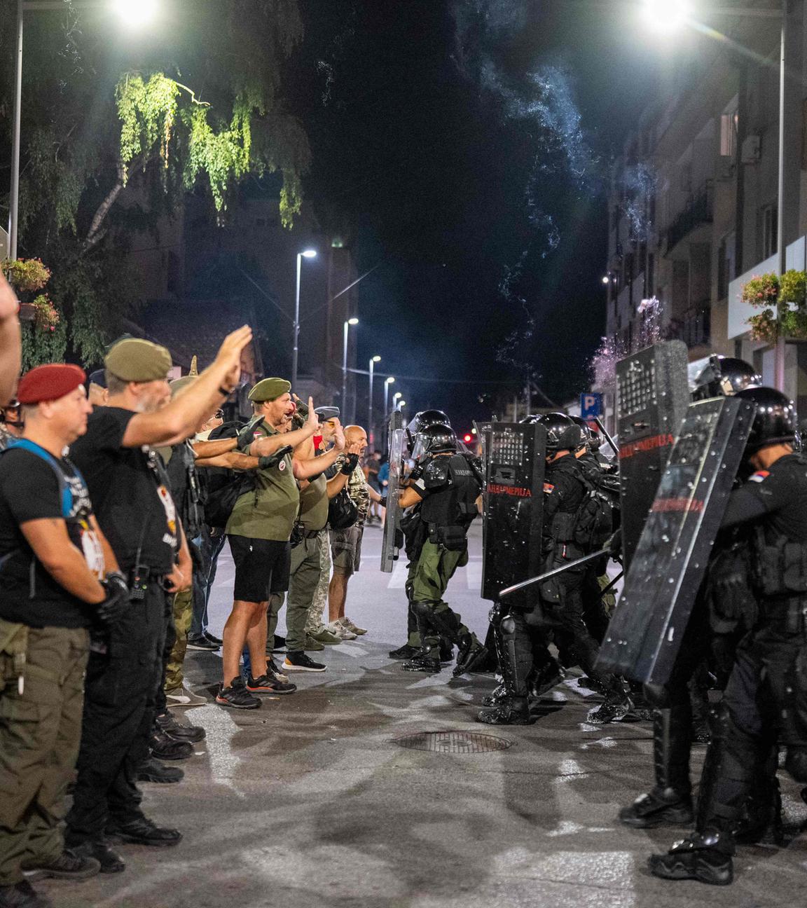 Demonstranten stehen während einer Anti-Regierungs-Kundgebung in Valjevo vor Bereitschaftspolizisten