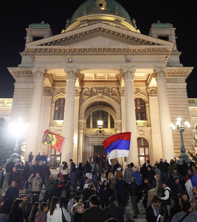 Vor dem Parlamentsgebäude feiern Menschen, nachdem der Vorsitzende der rechtsgerichteten Serbischen Fortschrittspartei (SNS), Vucic, seine Niederlage bei der Parlamentswahl eingestanden hat.