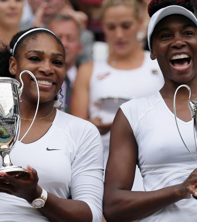 Serena und Venus Williams posieren nach ihrem Wimbledon-Sieg 2016 mit Pokalen