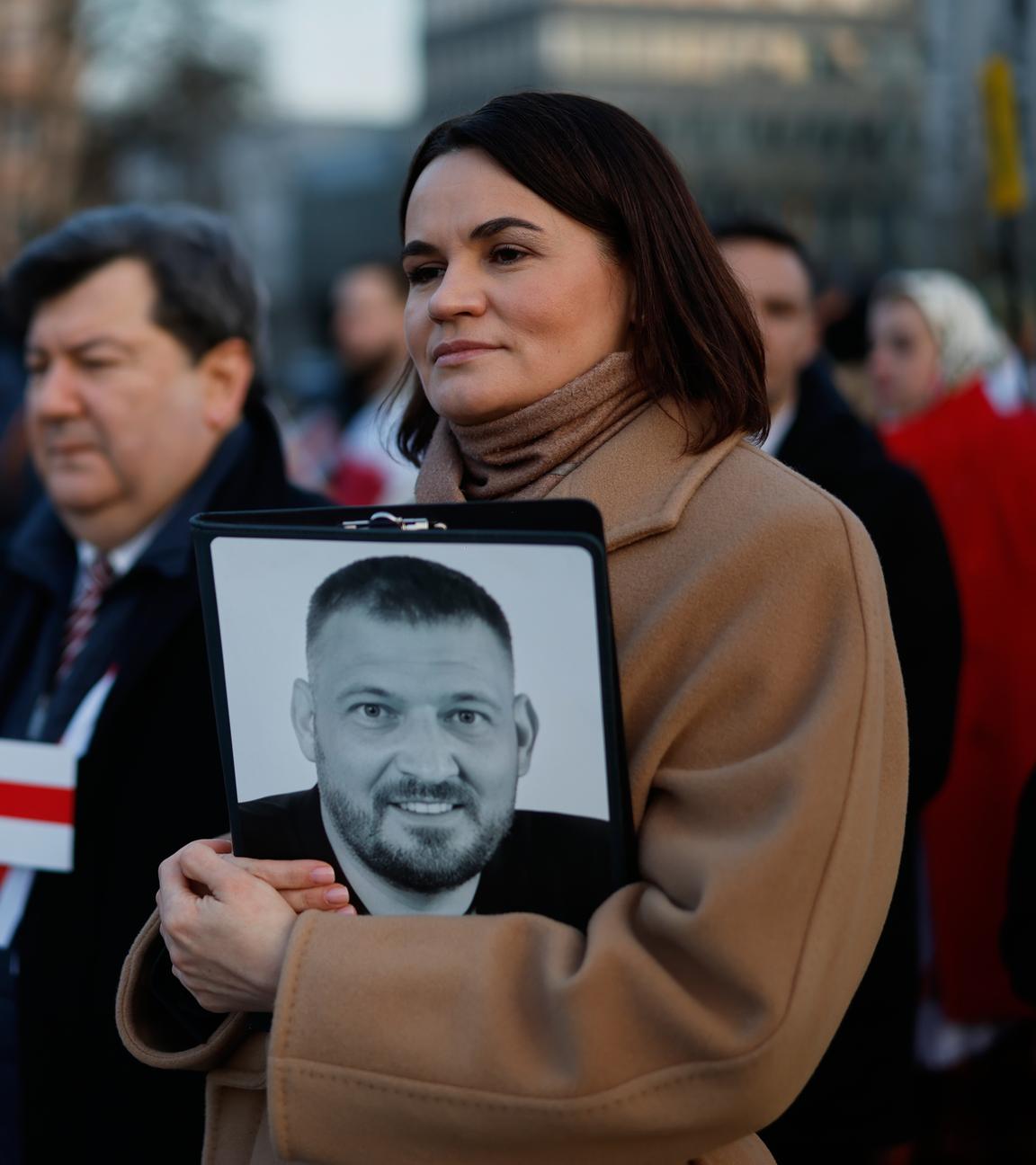 25.03.2025, Litauen, Vilnius: Die belarussische Oppositionsführerin Swetlana Tichanowskaja (r) hält ein Foto ihres inhaftierten Ehemanns, während sie an einer Feier zum 107. Jahrestag der Unabhängigkeitserklärung der Belarussischen Volksrepublik teilnimmt.