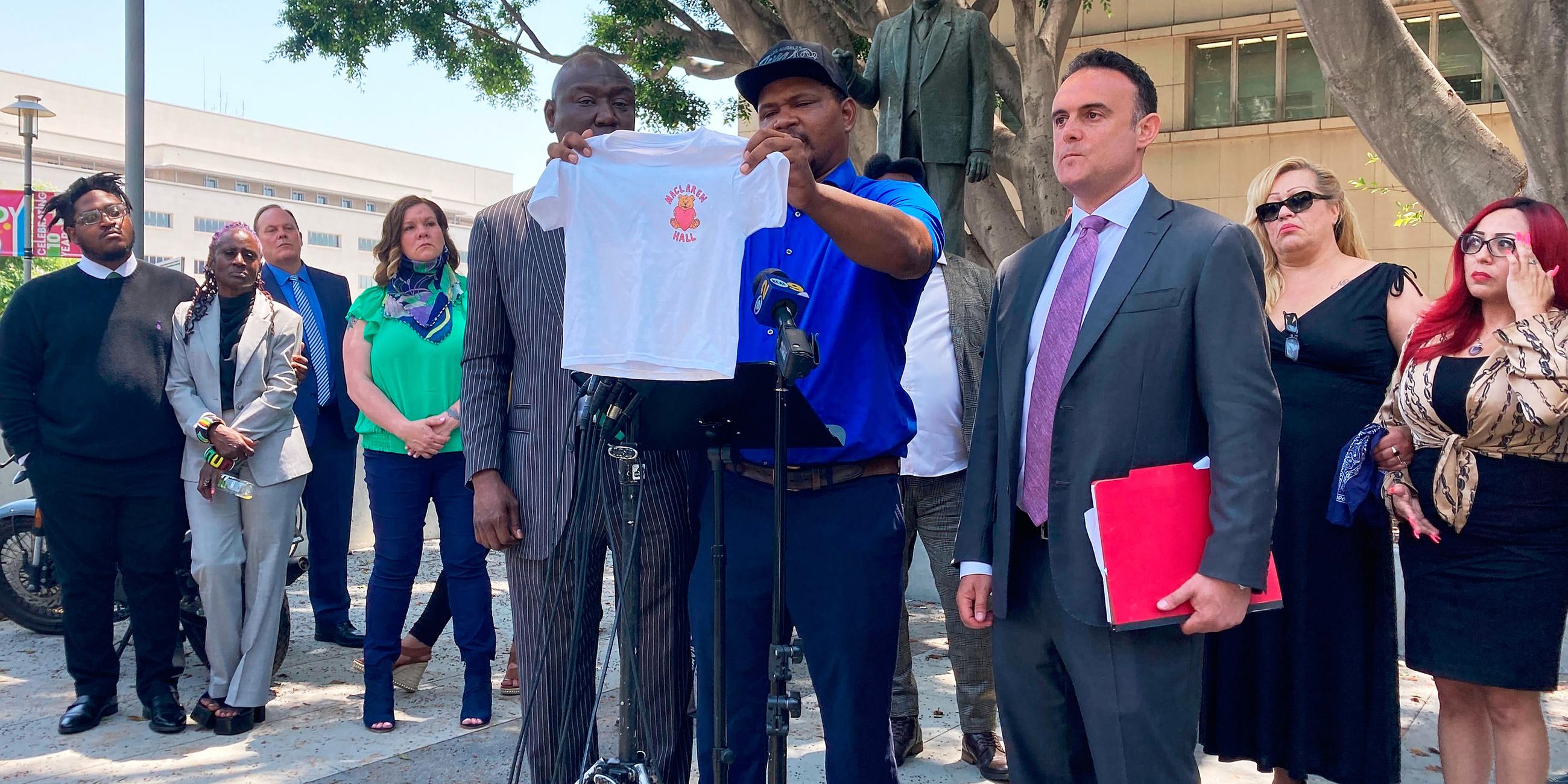 Jonathan Wright hält während einer Pressekonferenz das T-Shirt hoch, das er bekam, als er als 8-Jähriger zum ersten Mal ins MacLaren Children's Center in El Monte kam