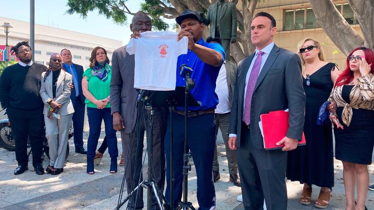 Jonathan Wright hält während einer Pressekonferenz das T-Shirt hoch, das er bekam, als er als 8-Jähriger zum ersten Mal ins MacLaren Children's Center in El Monte kam