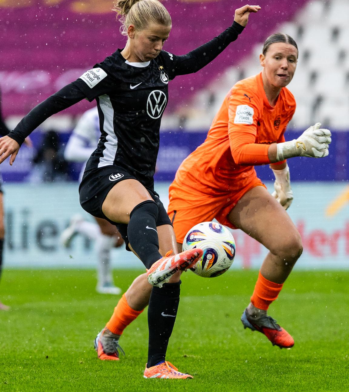 Justine Kielland (VfL Wolfsburg) hat die Essener Torhüterin Kim Sindermann überspielt und schießt aufs Tor.