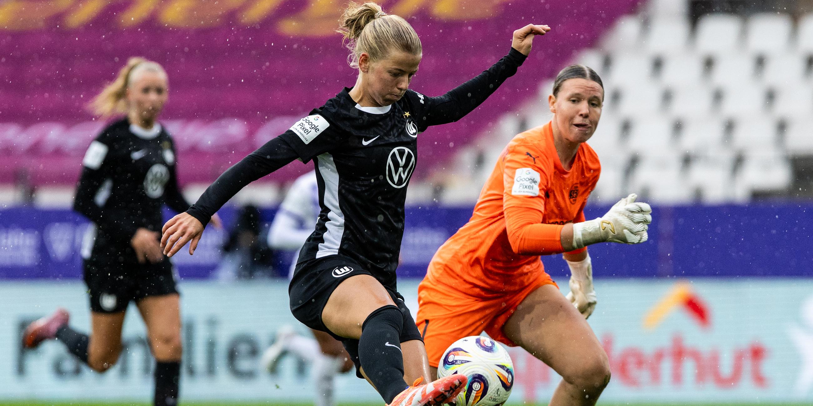 Justine Kielland (VfL Wolfsburg) hat die Essener Torhüterin Kim Sindermann überspielt und schießt aufs Tor.