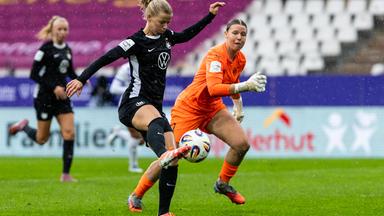 Justine Kielland (VfL Wolfsburg) hat die Essener Torhüterin Kim Sindermann überspielt und schießt aufs Tor.