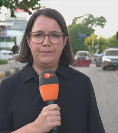 ZDF-Korrespondentin Gaa hält ein Mikrofon, im Hintergrund ist der Straßenverkehr von Islamabad zu sehen.