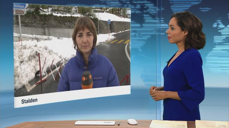 Schnee liegt auf Bänken und Stühlen auf einer Terrasse.