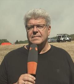 ZDF-Reporter Thomas Münten ist in Hürtgenwald zu sehen, im Hintergrund der verrauchte Himmel während des Waldbrandes.