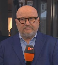 ZDF-Korrespondent Röller ist mit einem Mikrofon zu sehen.