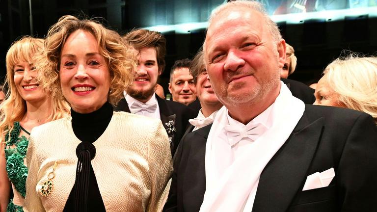 Sharon Stone ist zu sehen, wie sie auf dem Wiener Opernball mit mehreren Menschen ein Foto macht.