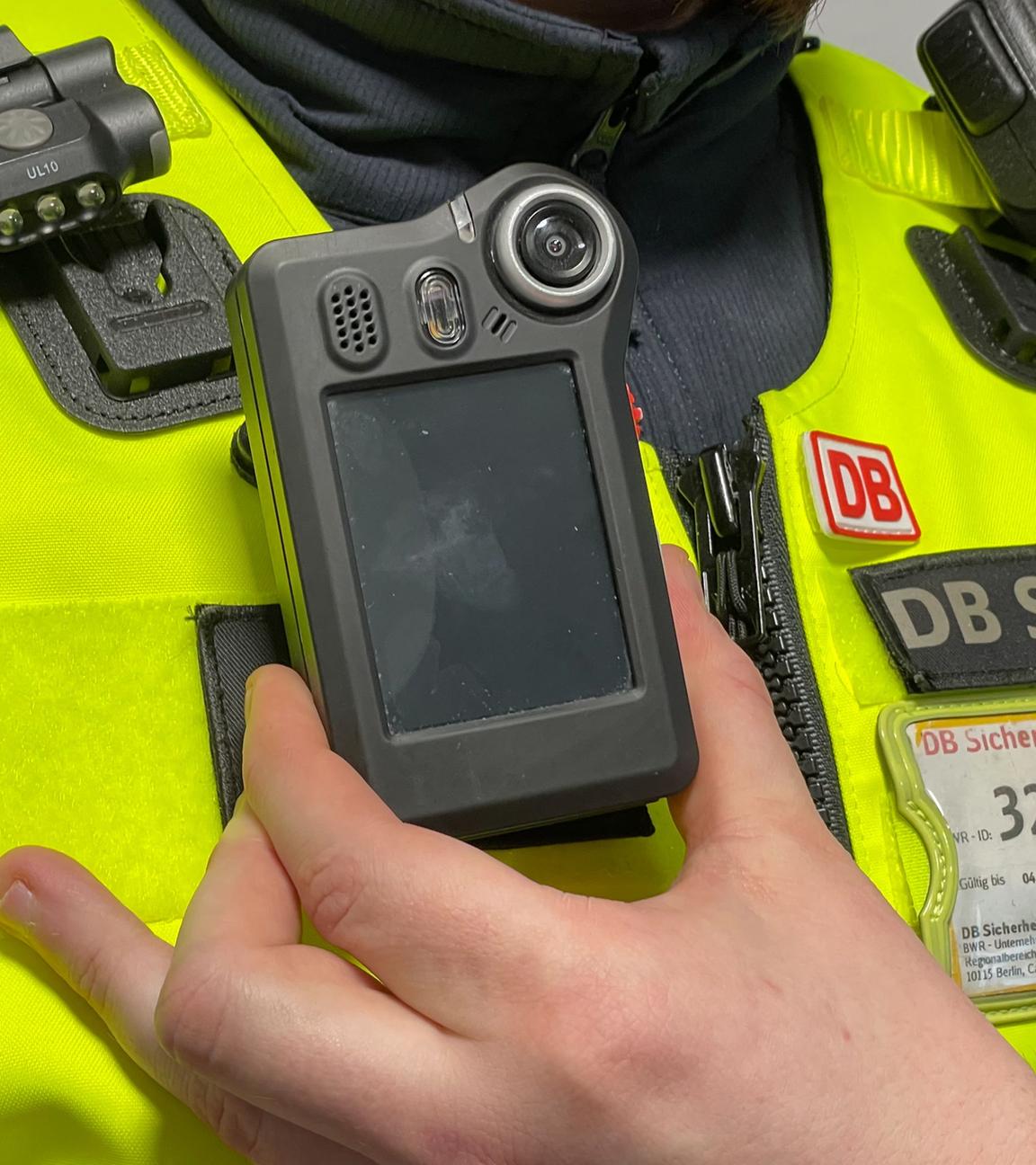 Ein Mitarbeiter der Deutschen Bahn präsentiert eine Bodycam.