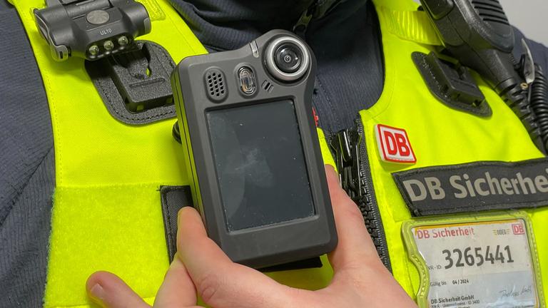 Ein Mitarbeiter der Deutschen Bahn präsentiert eine Bodycam.