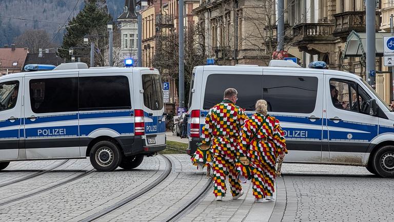 Karnevalisten und Polizeifahrzeuge in Freiburg