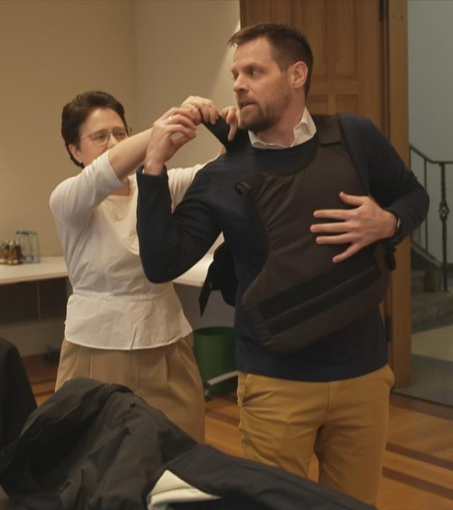 Gerichtsvollzieher zieht schusssichere Weste an