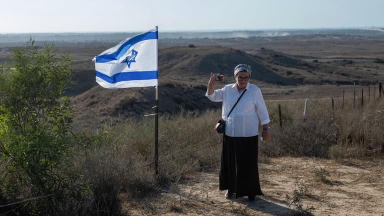 Daniella Weiss, Gründerin der rechtsextremen israelischen Siedlerorganisation Nachala, steht während eines Marsches zur Grenze mit Gaza neben einer israelischen Flagge.