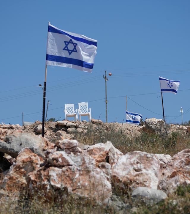 Israelische Flaggen flattern auf einem Hügel, der an palästinensische Grundstücke angrenzt am 23.05.2025 in Bruqin.