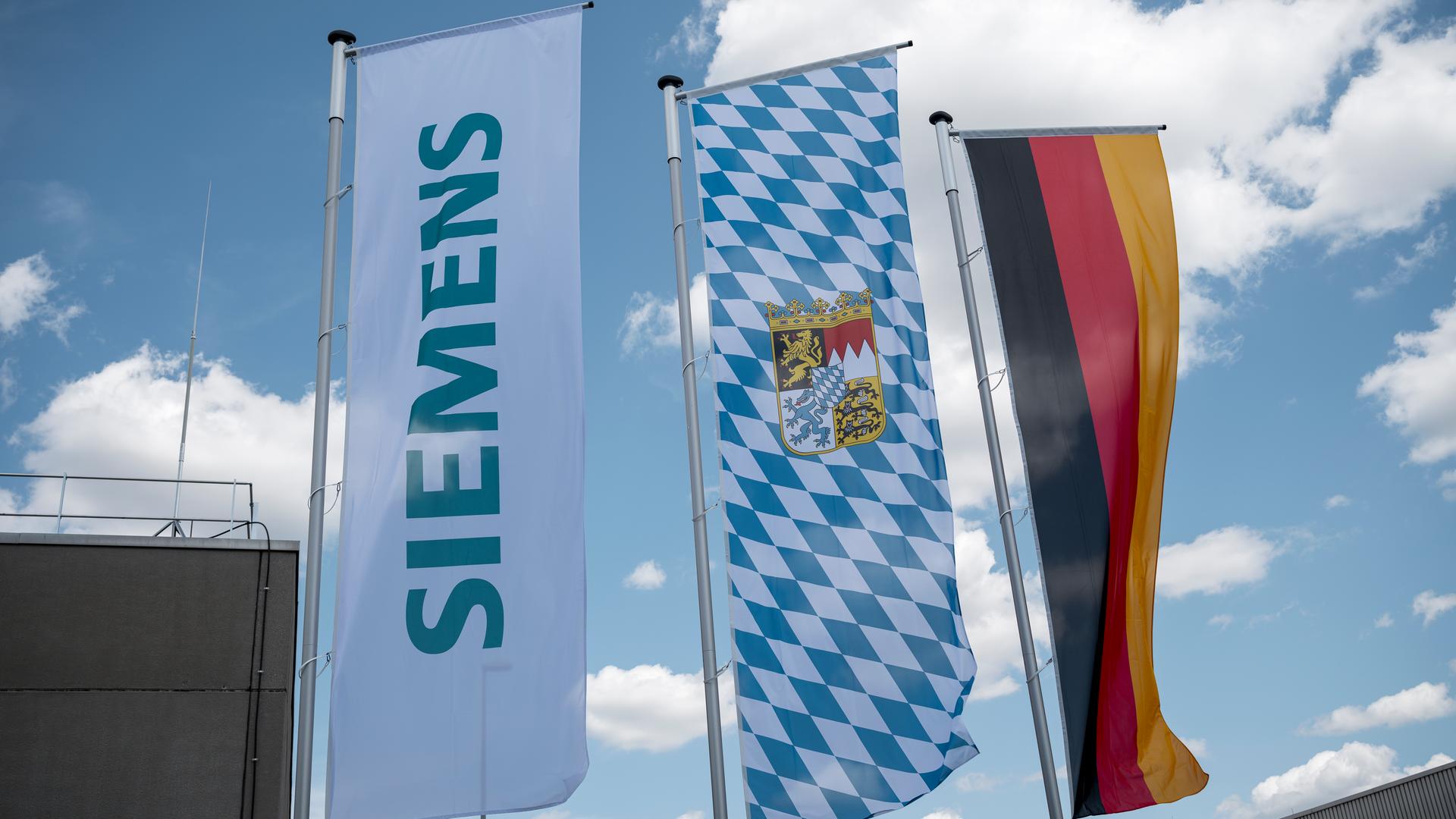 ie Fahnen des Unternehmens Siemens, die Fahne des Freistaats Bayern und die Deutschlandfahne wehen auf dem Gelände der Siemens AG.