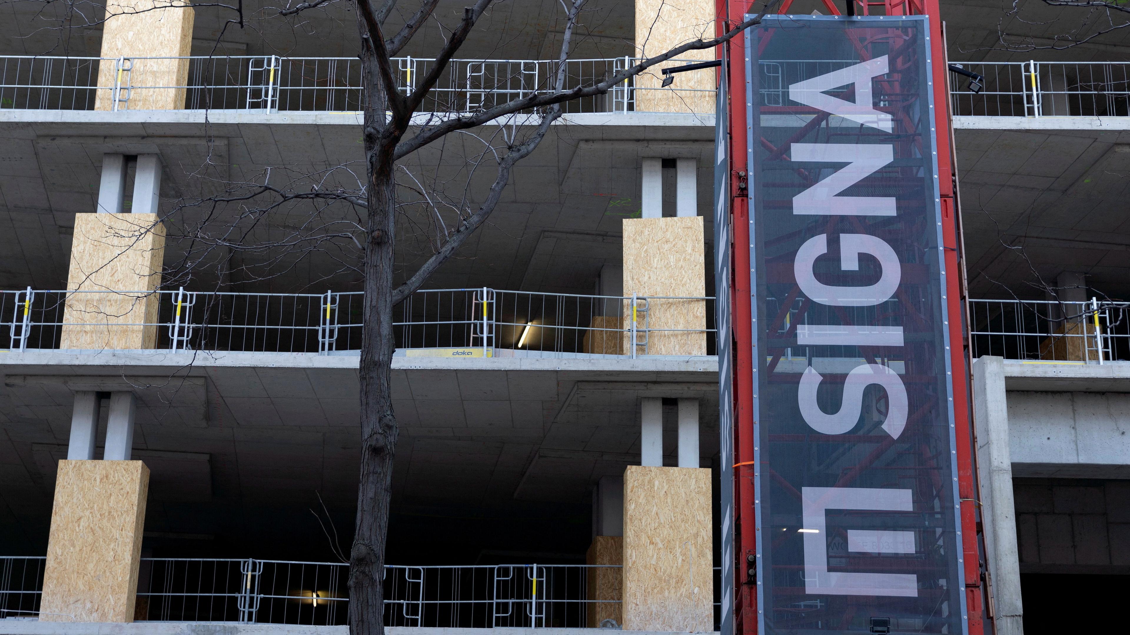 Das Schild der Signa Holding wird am 19. 12. 2023 auf einem Kran neben einer Baustelle in Wien, Österreich, angebracht. 