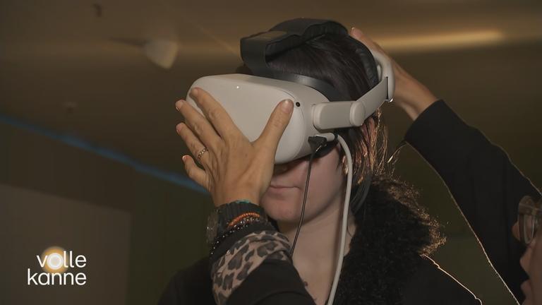 Frau bekommt beim Silbersalz Festival in Halle eine Virtual Reality-Brille aufgesetzt.