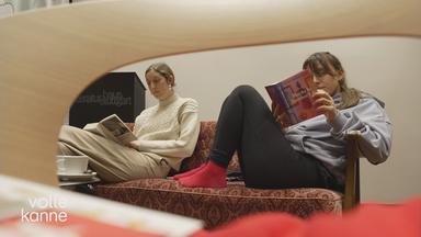 Zwei Frauen lesen auf einem Sofa