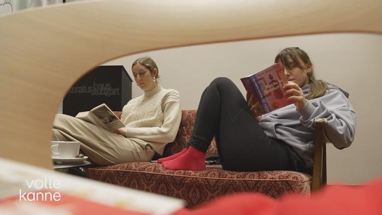 Zwei Frauen lesen auf einem Sofa