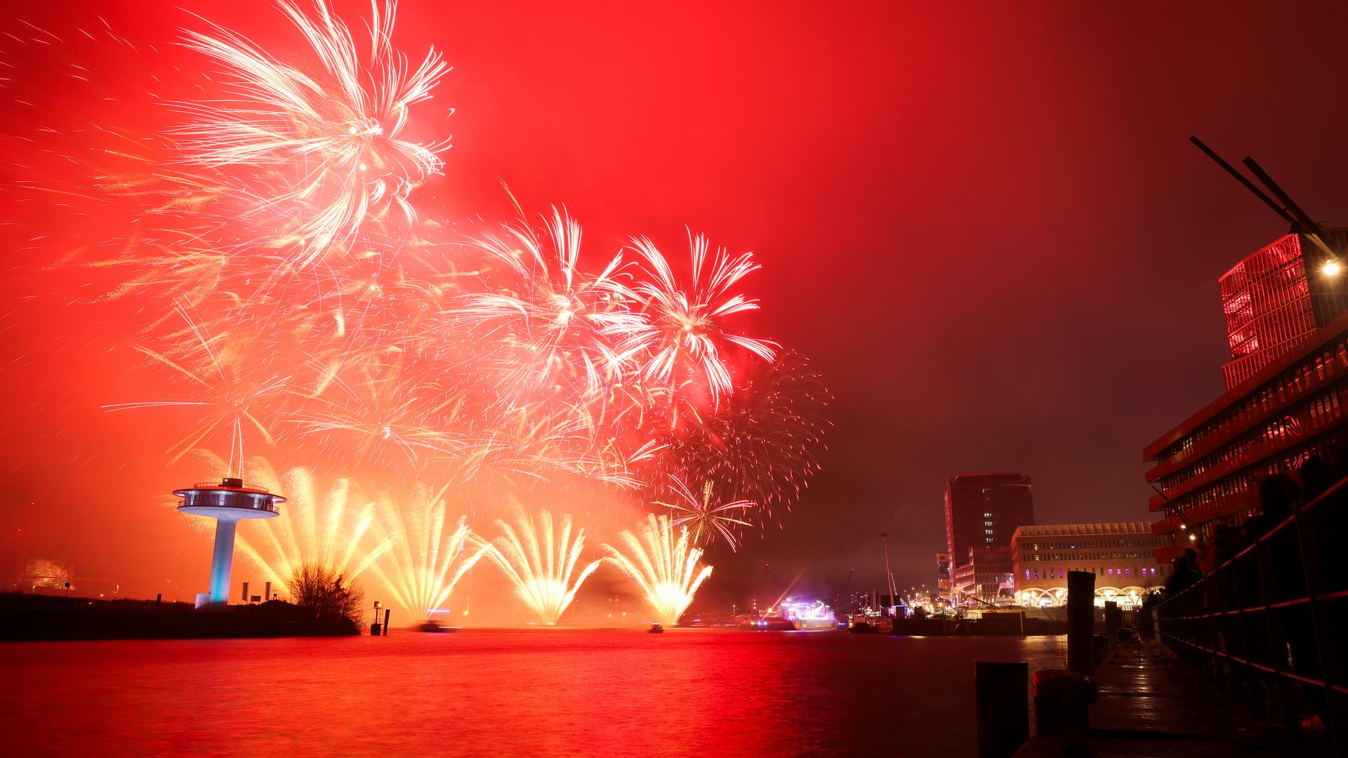Blick auf das Silvesterfeuerwerk hinter der schwimmenden Bühne der ZDF-Silvestershow am Chicagokai vor dem Westfield Hamburg-Überseequartier in der Hafencity