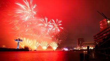 Blick auf das Silvesterfeuerwerk hinter der schwimmenden Bühne der ZDF-Silvestershow am Chicagokai vor dem Westfield Hamburg-Überseequartier in der Hafencity