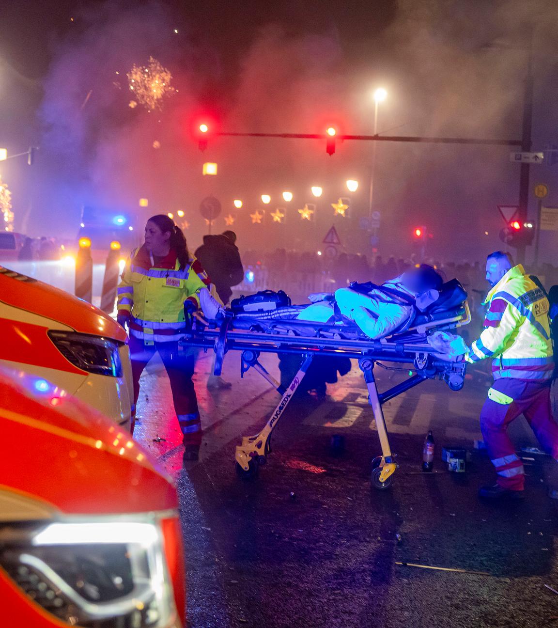 Hessen, Frankfurt/Main: Eine verletzte Person wird von Sanitätern während des Feuerwerks zum Jahreswechsel am Mainufer abtransportiert.