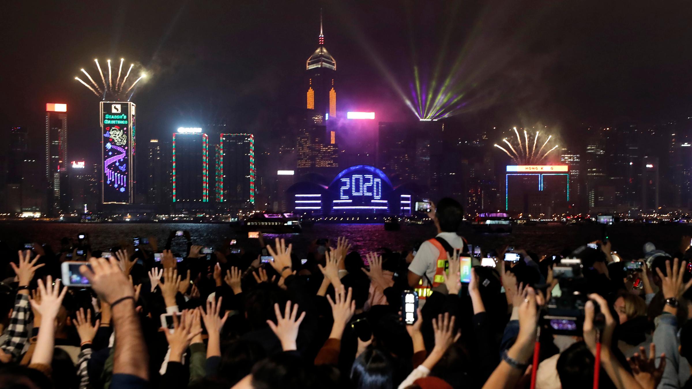 01.01.2020, china, hongkong: regierungskritische demonstranten halten waehrend feierlichkeiten zu neujahr ihre haende in die hoehe. 