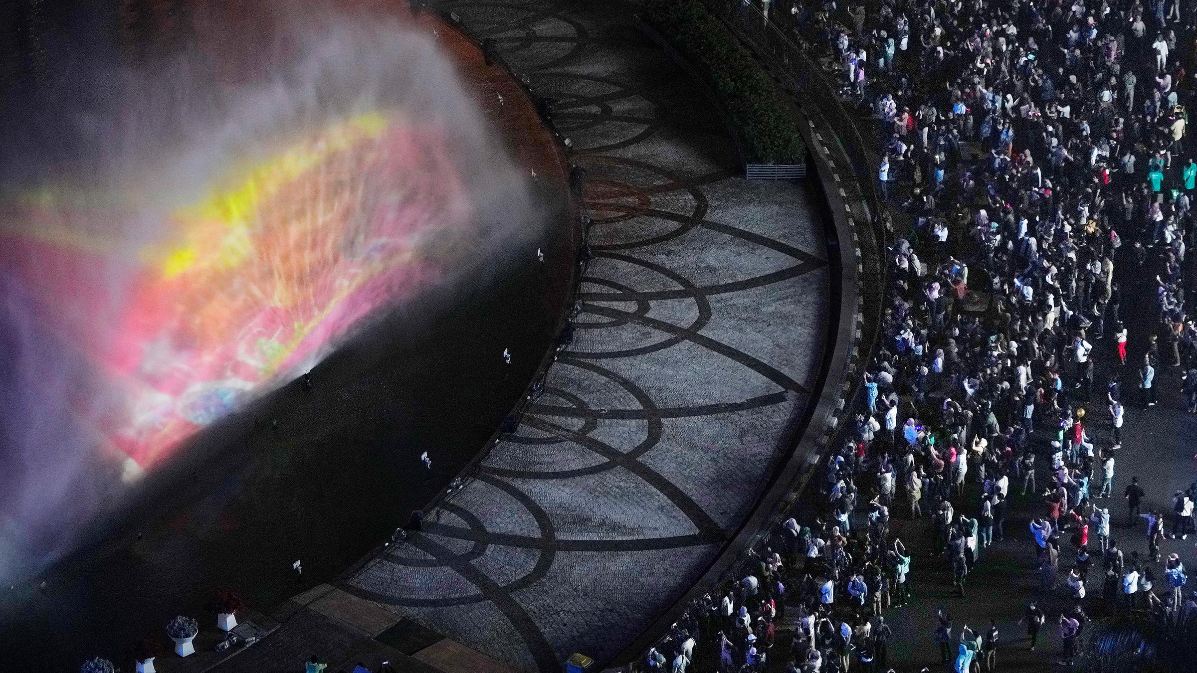 In Djakarta treffen sich Feierlustige an einem beleuchteten Springbrunnen.