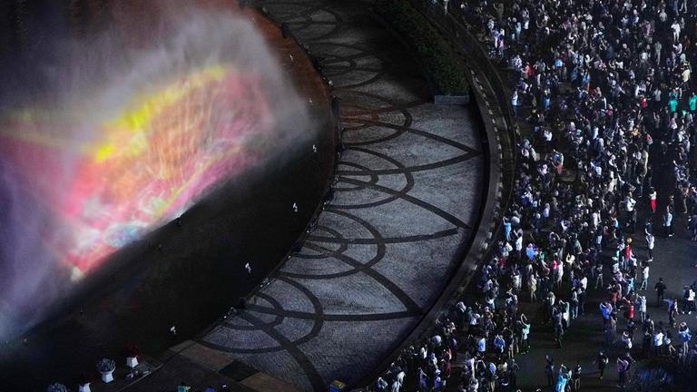 In Djakarta treffen sich Feierlustige an einem beleuchteten Springbrunnen.