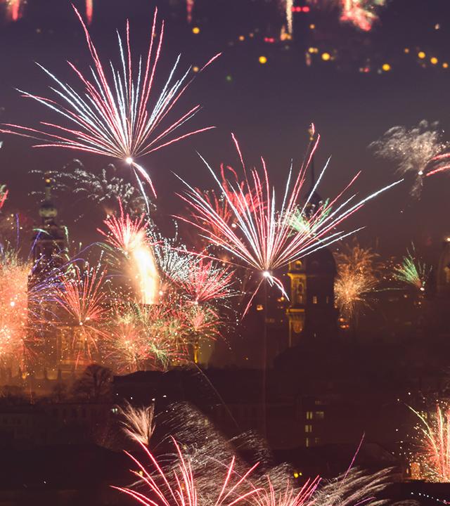 Feuerwerk vor einer Stadt bei Nacht