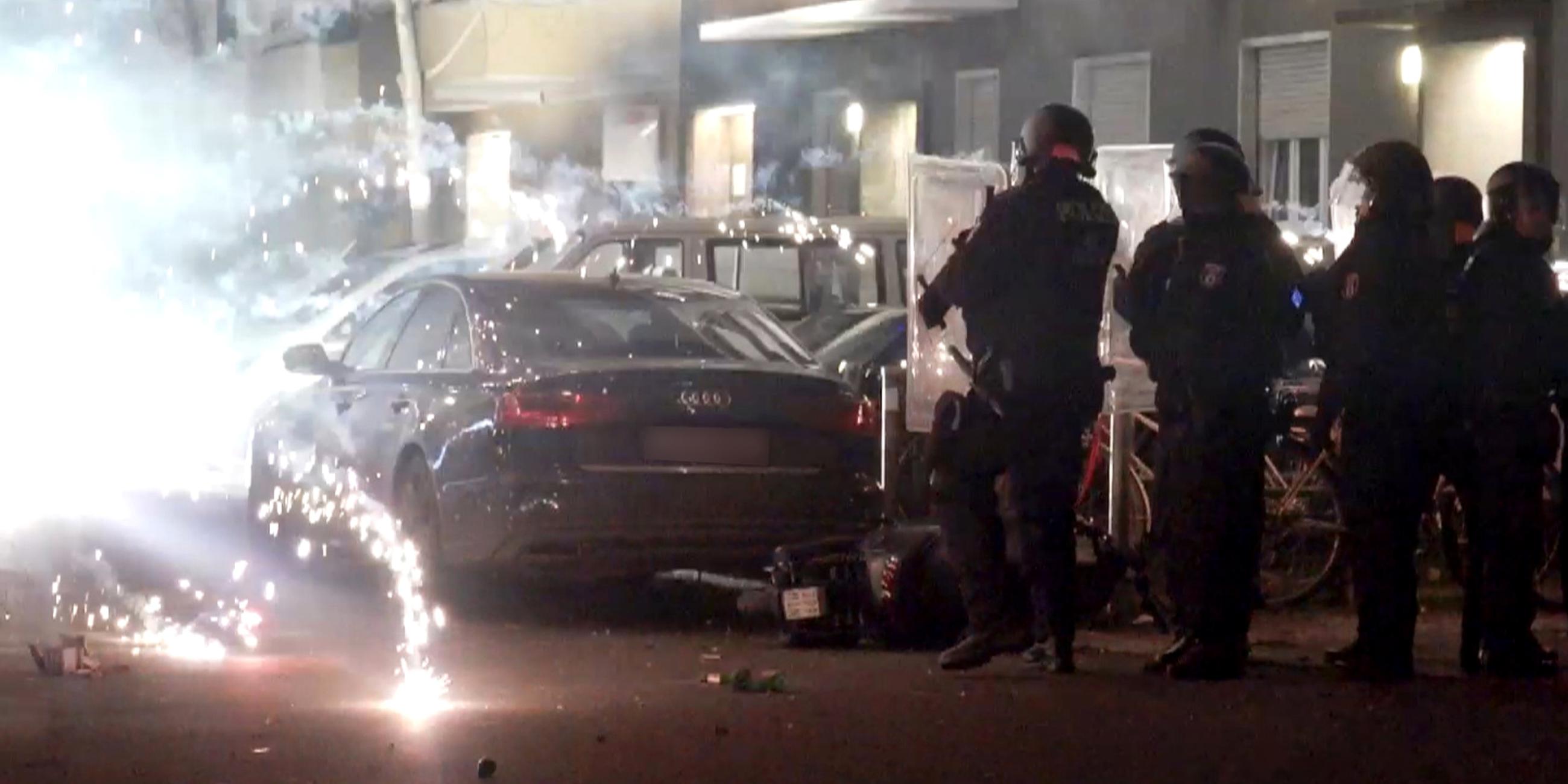 Polizeibeamte stehen hinter explodierendem Feuerwerk.