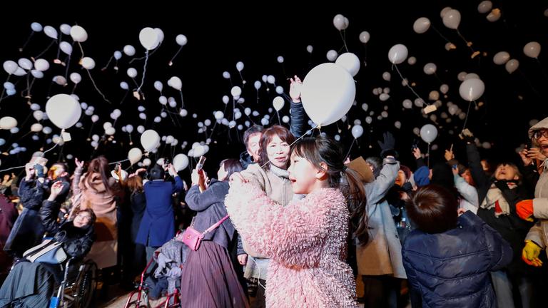 Teilnehmer beim Silvestercountdown in Tokio, Japan, lassen Ballons fliegen.