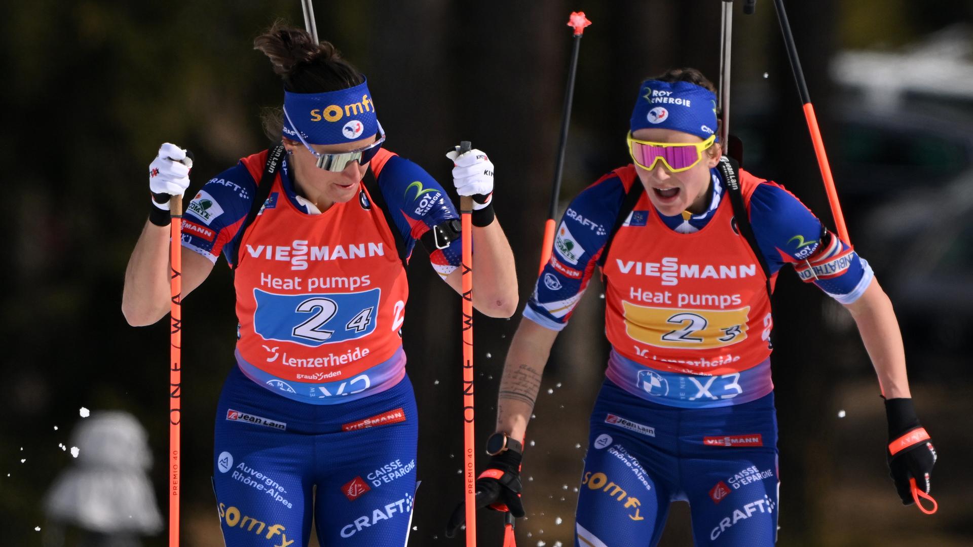 Julia Simon (links) und Treamkollegein Justine Braisaz-Bouchet beim Wechsel im Staffelrennen der WM 2025 in Lenzerheide. 