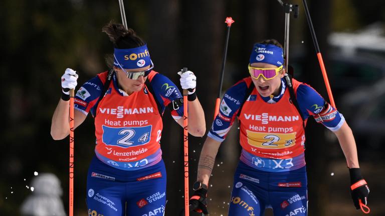 Julia Simon (links) und Treamkollegein Justine Braisaz-Bouchet beim Wechsel im Staffelrennen der WM 2025 in Lenzerheide. 