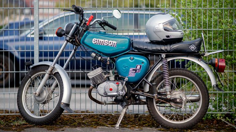 Ein Kleinkraftrad vom Typ Simson S 51 B steht auf einem Parkplatz. 